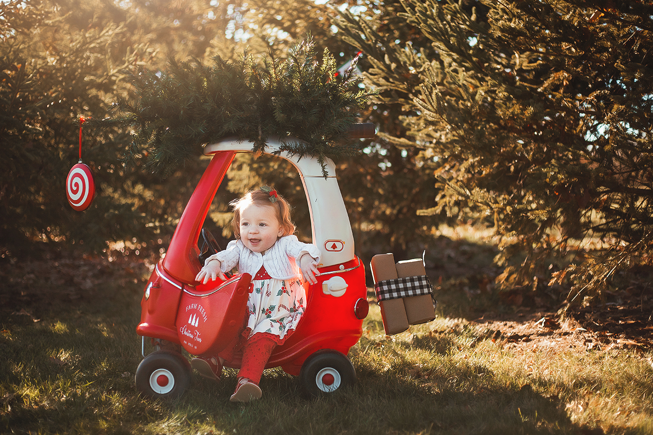 Little girl getting out of a Christmas Cozy Coupe