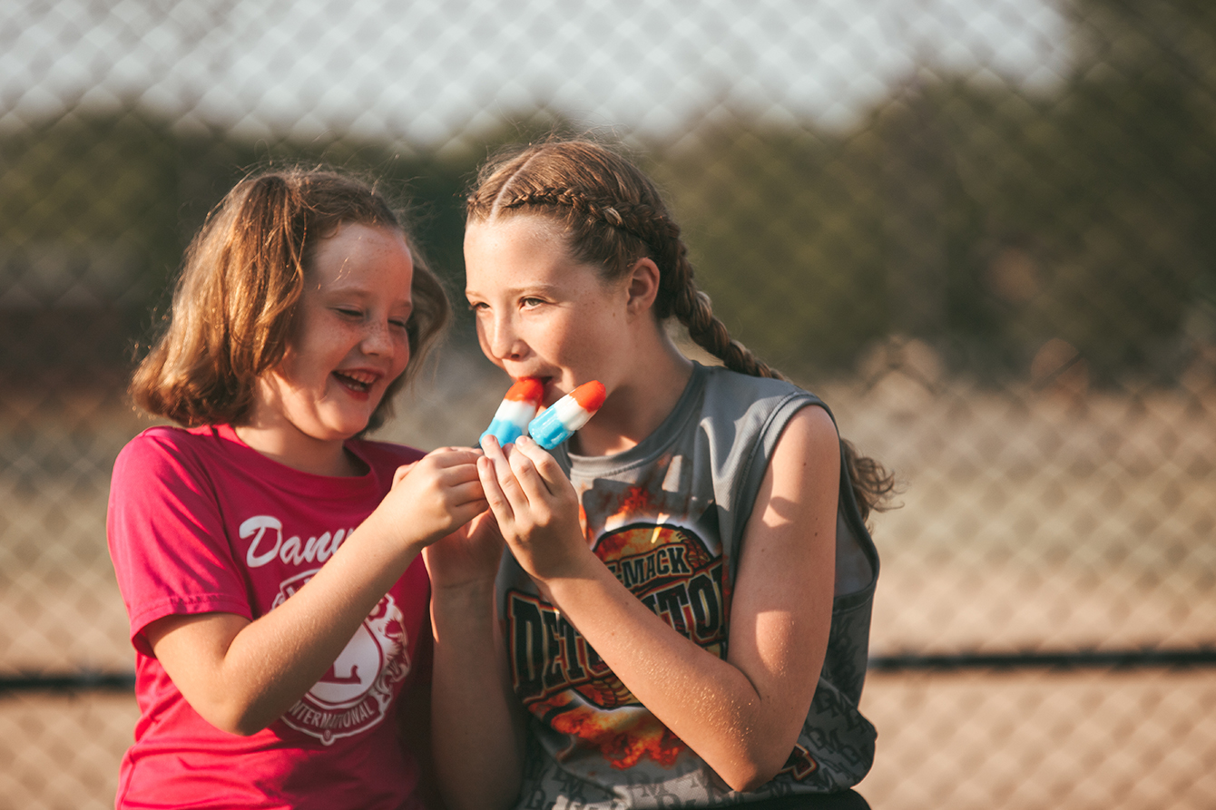 Two girls sharing a popsicle on a summer afternoon — Bloomington Normal family photographer Martina Newport Photography.